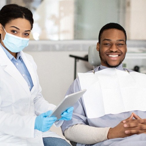 Un dentista habla con un paciente sobre salud bucal