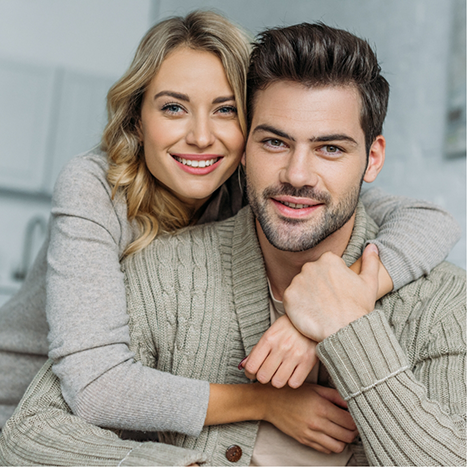Smiling man and woman hugging at home