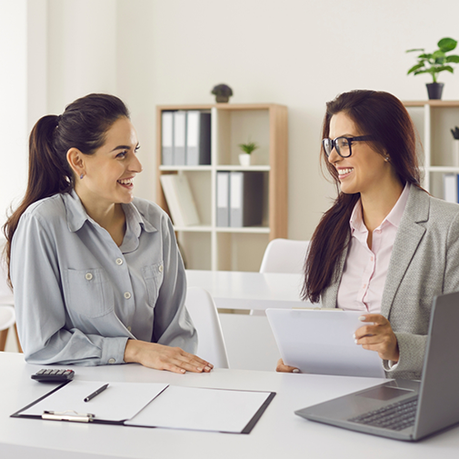 Two women looking at paperwork at a desk