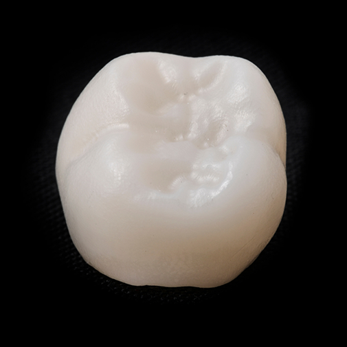 Tooth colored dental crown against a black background