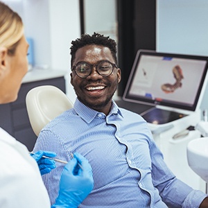 Smiling patient talking to dentist in treatment chair