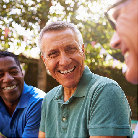 Three men laughing together outdoors after receiving dental services in Rogers